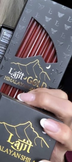 Hands holding the Lajit Gold honey sticks box and a Himalayan Shilajit box